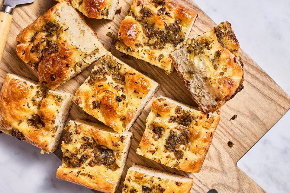 Top down view of stuffing focaccia chunks on a cutting board.
