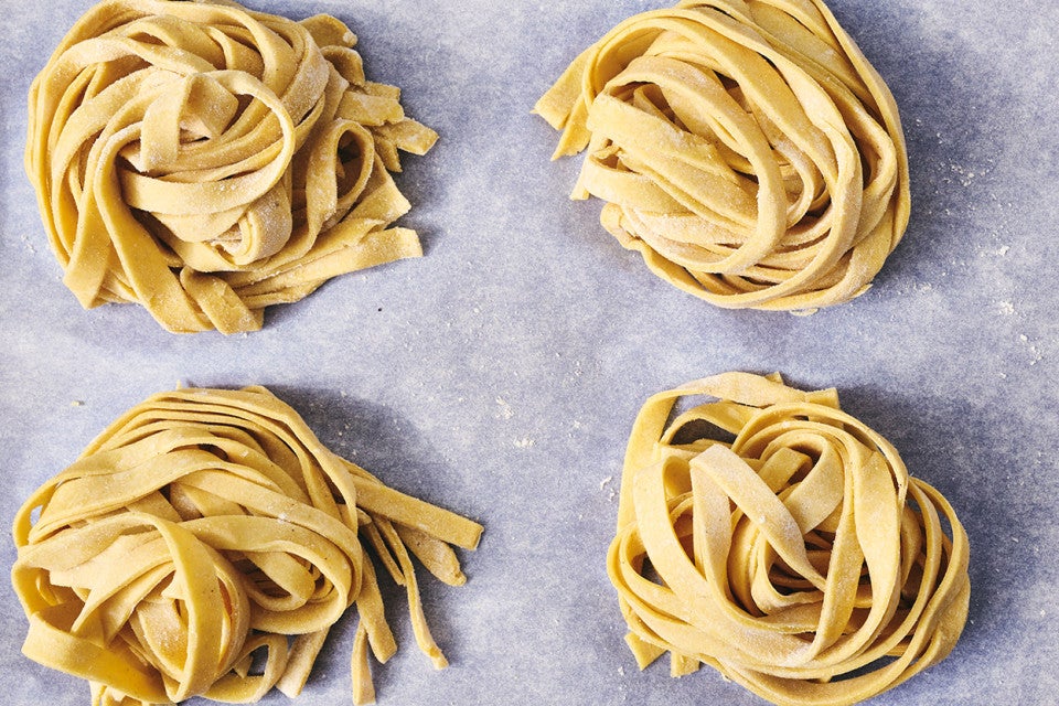Overhead photograph of raw balls of gluten free pasta on parchment paper.