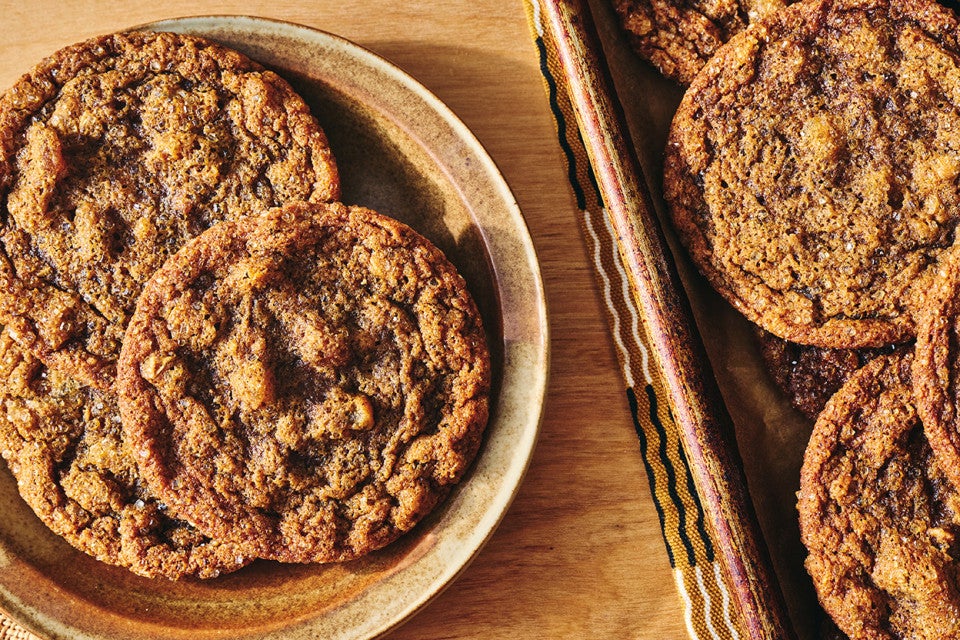 Overhead view of Cape Cod Soft Molasses Cookies shown on a plate and also on a baking sheet.