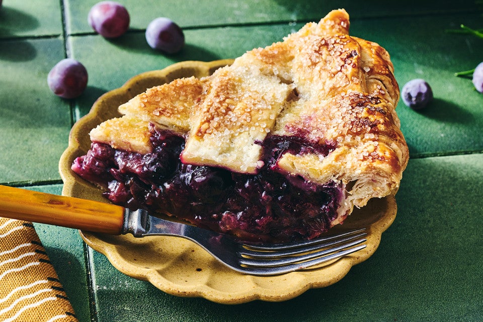 Concord Grape Pie seen from the side with dark blue and purple filling.