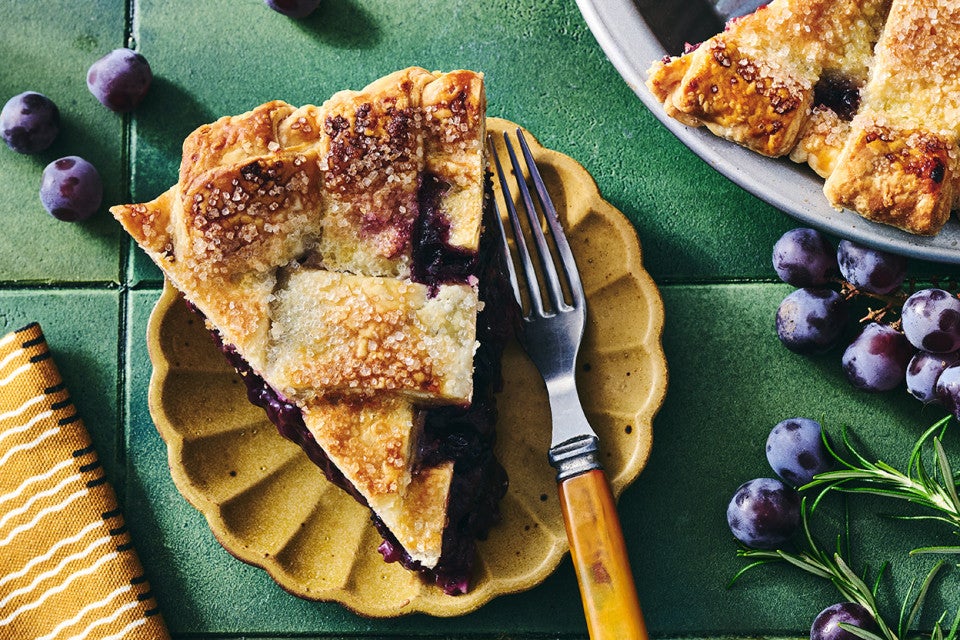 Concord Grape Pie sliced and arranged on a plate with a fork.