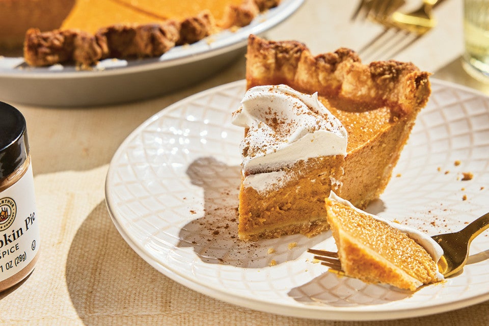 A slice of Smooth and Spicy Pumpkin Pie topped with whipped cream