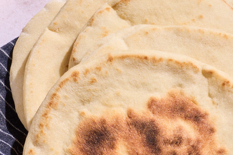 A detailed image of Sourdough Pita Bread seen from above showing a nice brown cooked finish.