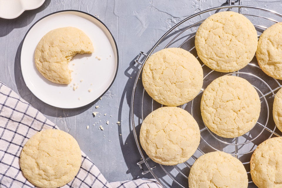 Sourdough Sugar Cookies on a baking rack and another on a white plate photographed from above.