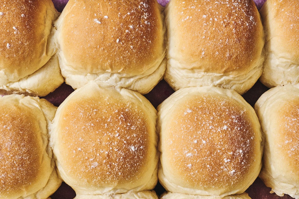 Close up of the golden tops of Big-Batch Quick Dinner Rolls on a sheet tray.