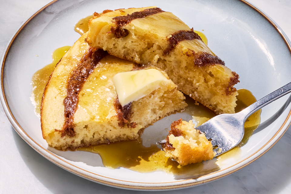 A Cinnamon Roll Skillet Pancake on a plate with some on a fork.