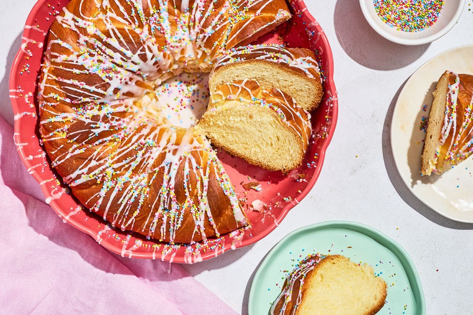 An Easter Bread Wreath partially sliced in a red, round, cake pan.