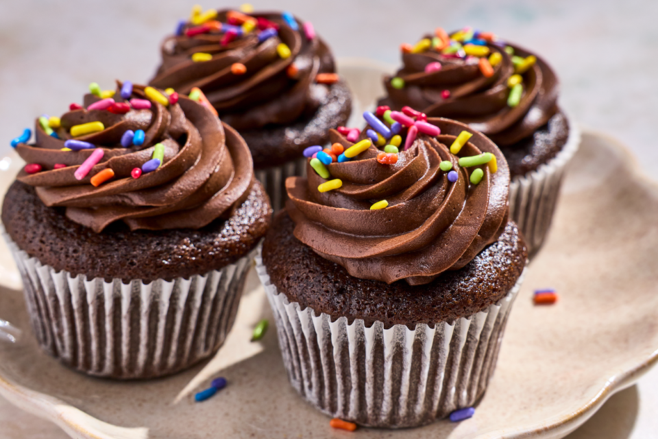 4 Small-Batch Chocolate Cupcakes on a plate with chocolate frosting and sprinkles.