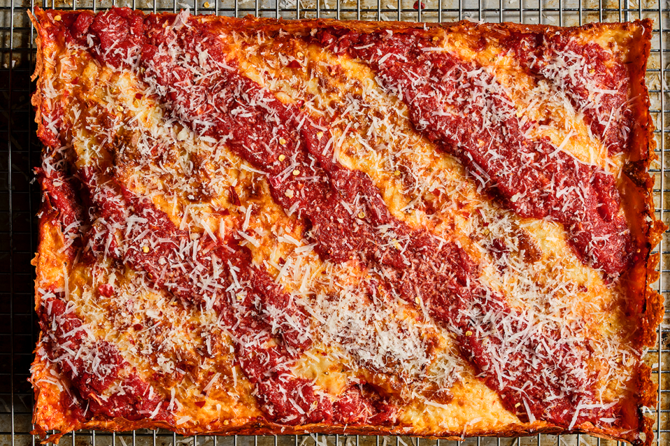 Detroit Pizza seen from above with classic cheese then sauce preparation.