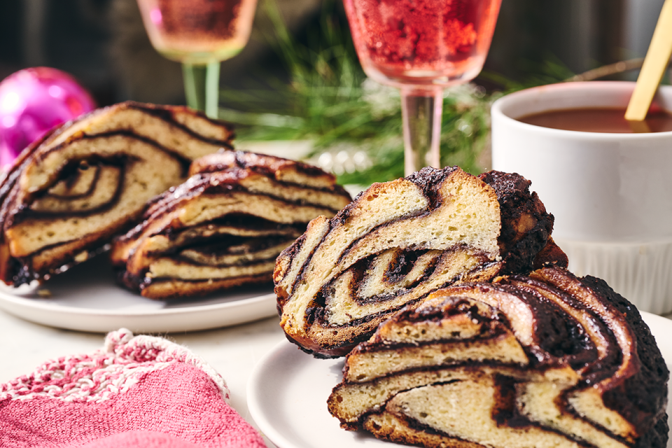 Slices from a chocolate babka wreath on a table setting.