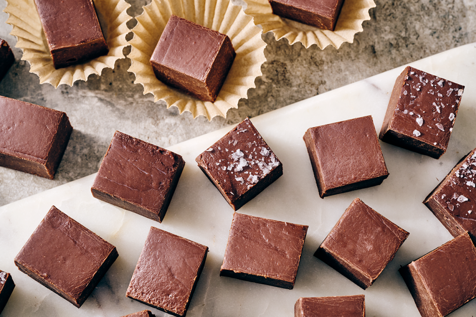Easy Microwave Fudge cut into neat squares and shown on a light colored marble counter.