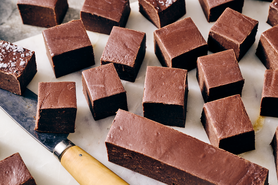Easy Microwave Fudge cut into neat squares and shown on a light colored marble counter.