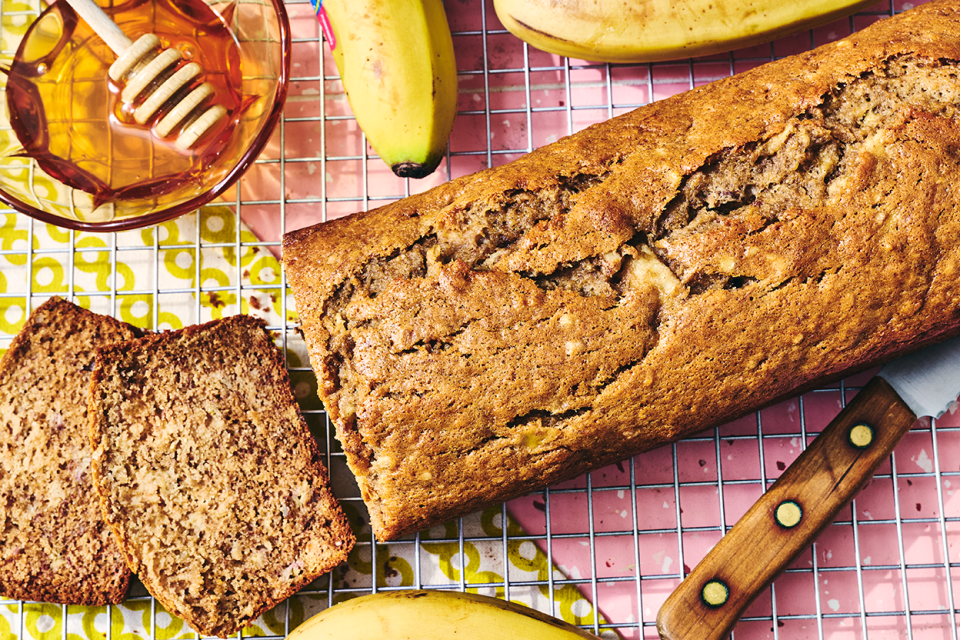 A loaf of Sourdough Banana Bread on a countertop with two pieces sliced and laying on their side.