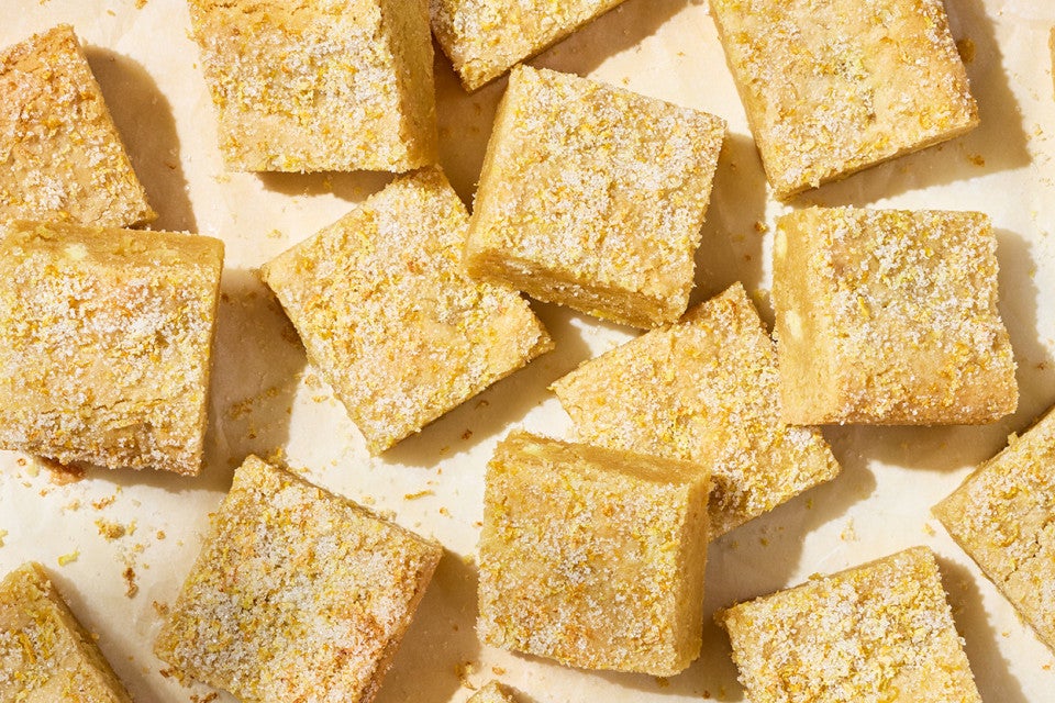 Alex Roberts Lemon Citrus Blondies on parchment paper atop a counter.
