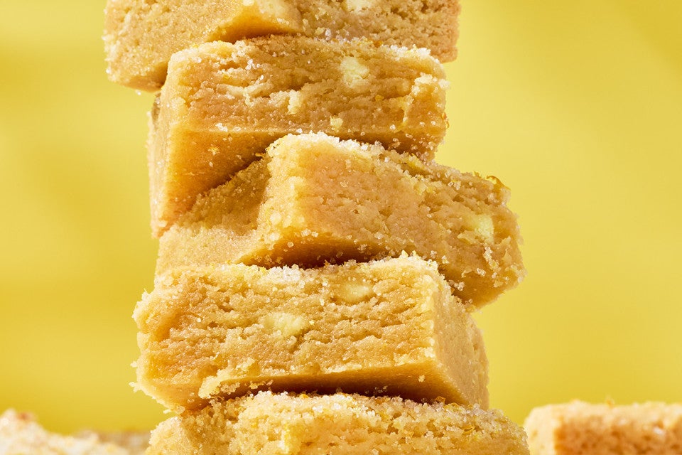 Detailed photograph of Alex Roberts Lemon Citrus Blondies stacked.