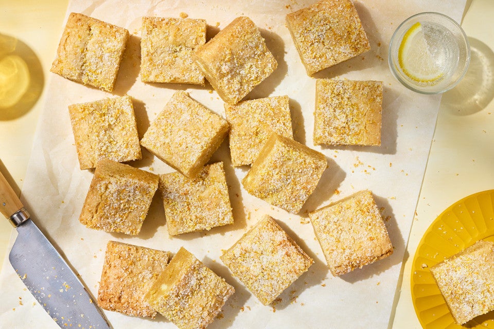 Alex Roberts Lemon Citrus Blondies on parchment paper atop a counter.