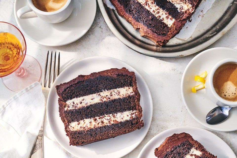 Chocolate Cassata Cake on a plate with a slice laying down showing layers of chocolate and creamy filling.
