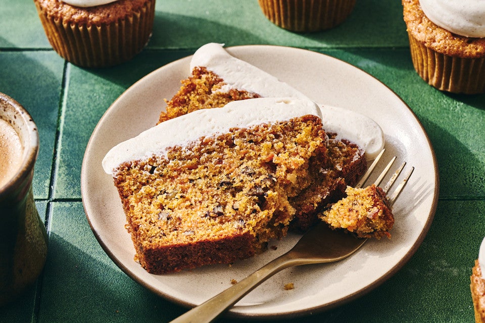 Sliced Spiced Carrot Snacking Cake on a plate with a bite on a fork.