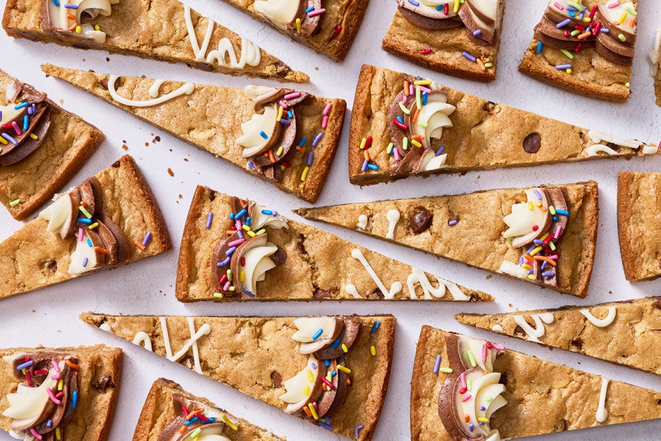 Slices of chocolate chip cookie cake arranged on a table.