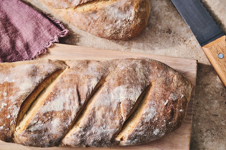A rustic loaf of bread on a cutting board.