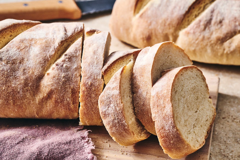 The easiest loaf of bread you'll ever bake shown sliced on a counter.