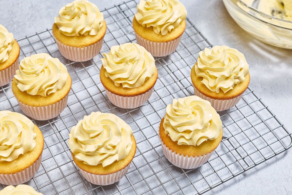 Cupcakes that are frosted with French Buttercream on a baking rack