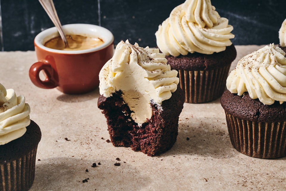 Detailed shot of an Irish Cream Cupcake sliced in half to show the frosting in the center as well as on top.