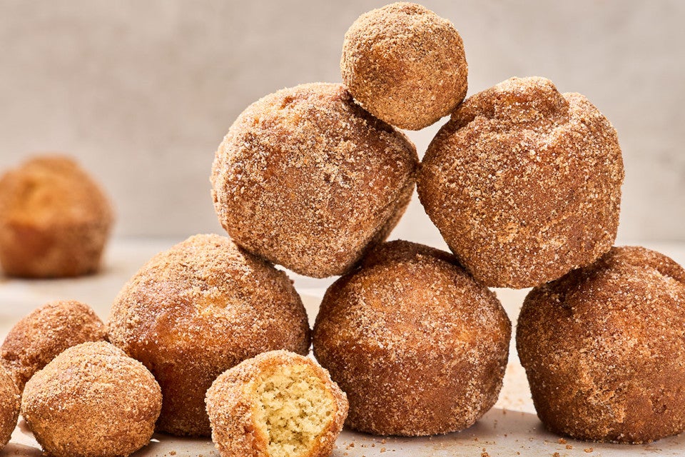 Maple French Toast Mini Muffins stacked together on a counter.