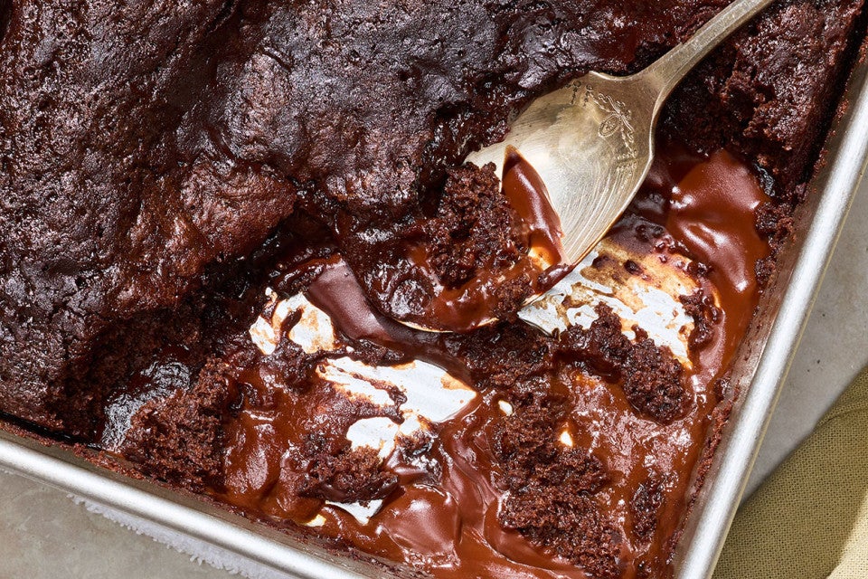 Sourdough Discard Chocolate Pudding Cake in a baking pan with a dollop on a spoon.
