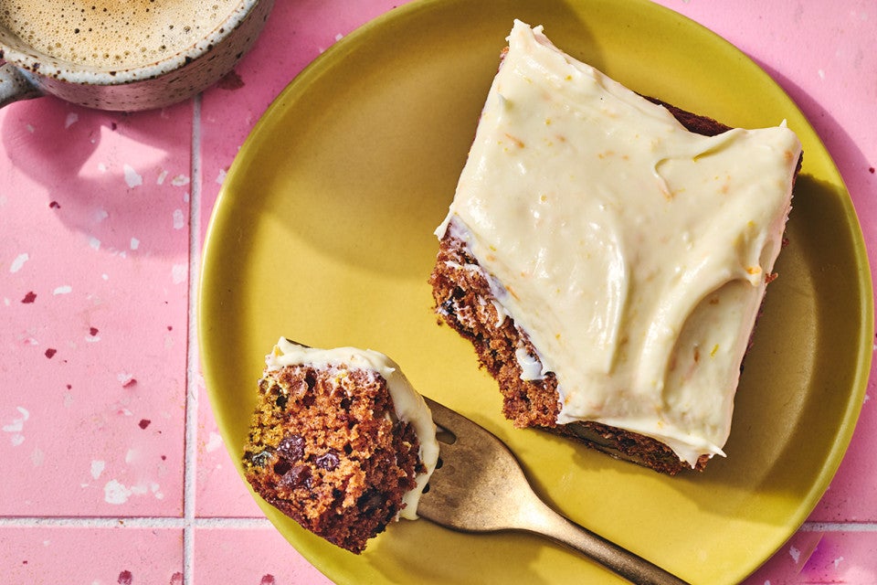 A slice of Tomato Soup Spice Cake on a yellow plate atop a pink tiled counter.