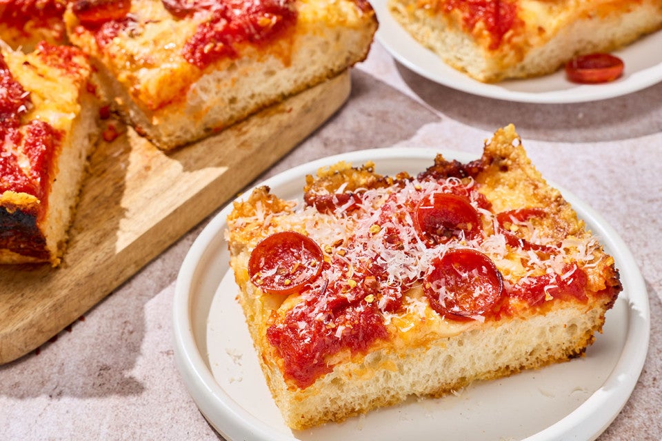 A slice of pepperoni Weeknight Detroit Pizza shown on a plate.