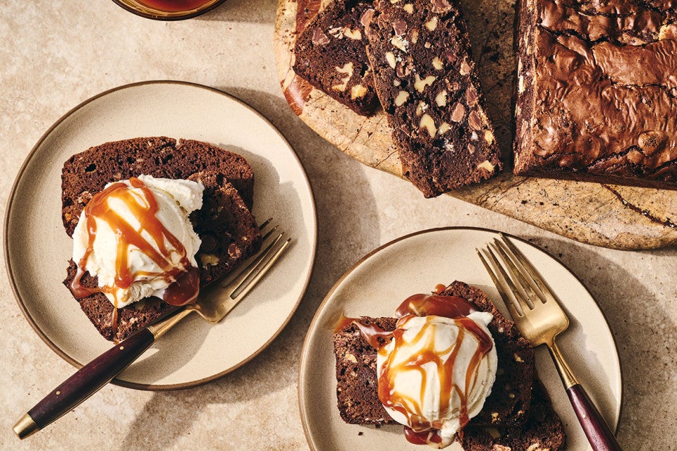 A sliced Brownie Loaf on a plate with vanilla ice cream and a caramel swirl