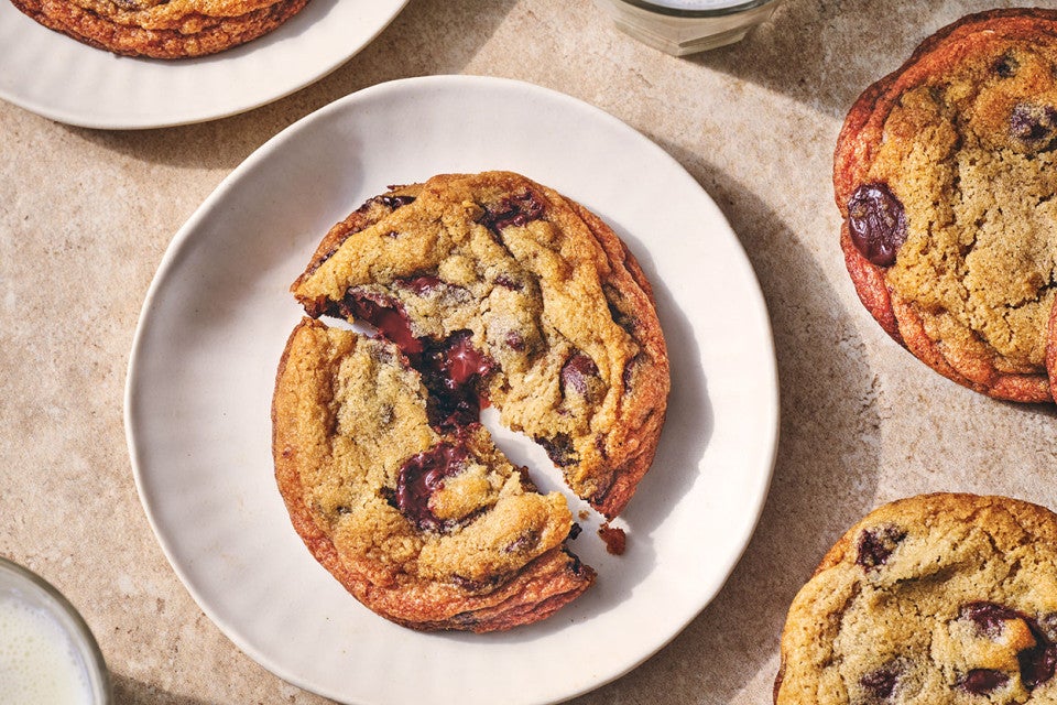 A Classic Chocolate Chip Cookie split on a white plate seen from overhead.
