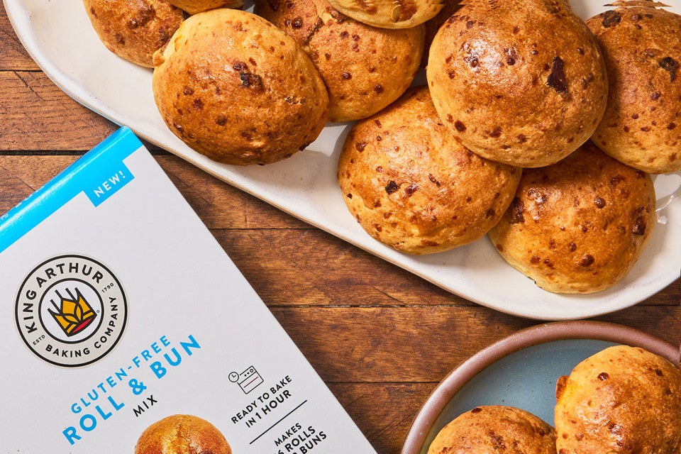 Gluten-Free Bacon Cheddar Rolls on a platter with a box of King Arthur Baking Gluten-Free Roll & Bun Mix..