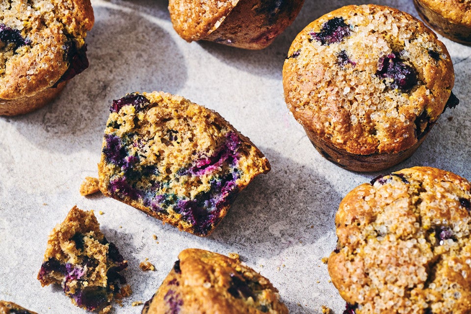 Sourdough Discard Blueberry Muffins with one broken to show the crumb.