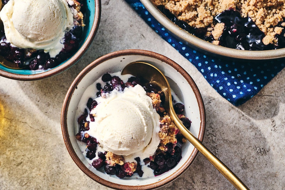 Blueberry Crisp in a round King Arthur Baking pie tin and also in a bowl topped with ice cream