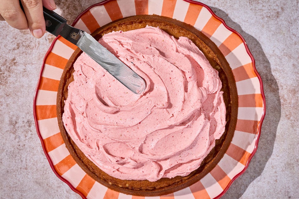Spreading frosting on a Brown Sugar Strawberry Frosted Cake