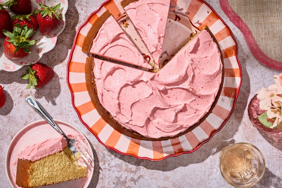 Brown Sugar Strawberry Frosted Cake sliced on a striped plate