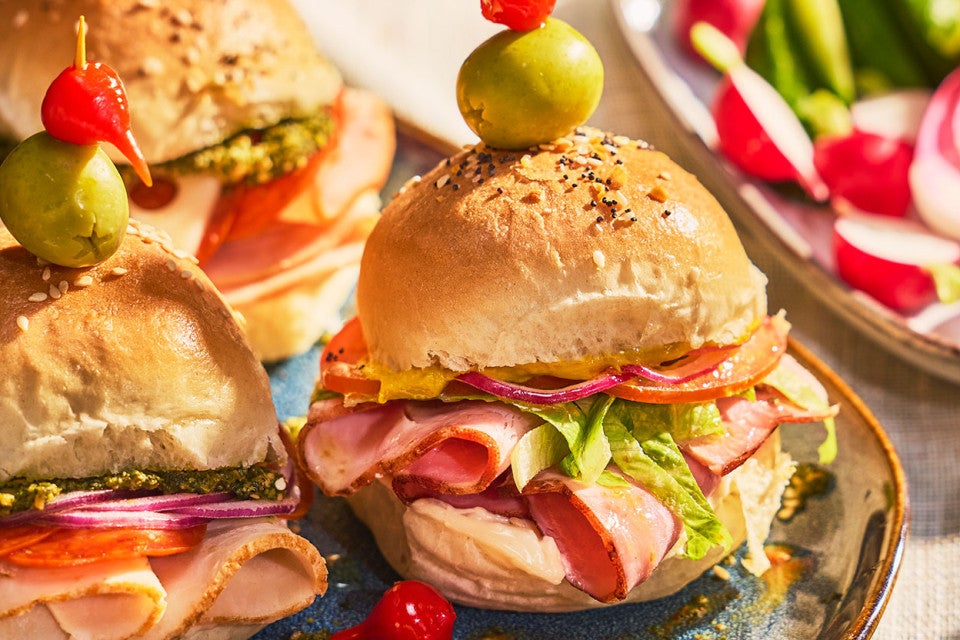 Hot Party Sandwiches on an elaborate table with other vegetables, dips, and lunch items