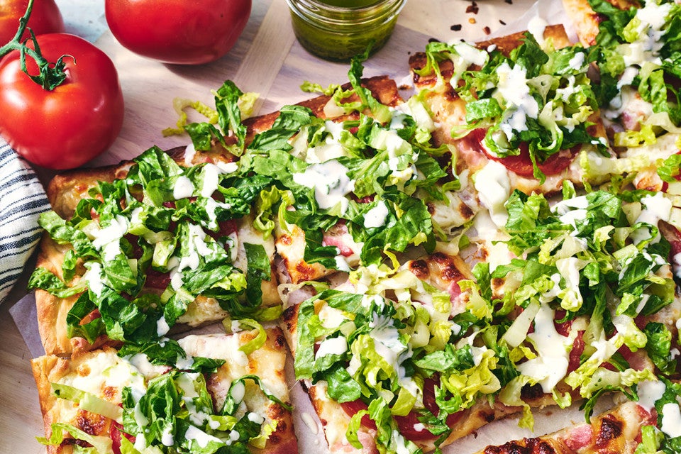 BLT Pizza sliced and covered with freshly chopped lettuce