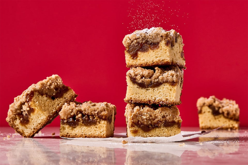 Apple Crumb Cake stacked in slices and shown against a dramatic red background