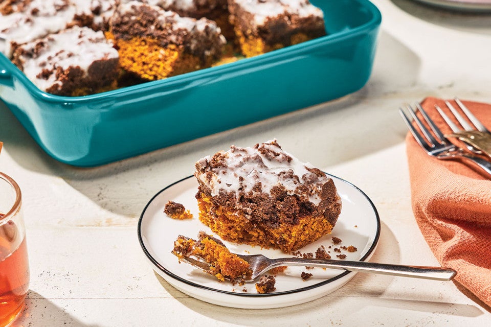 Chocolate Pumpkin Crumb Cake on a plate with a teal baking pan in the background