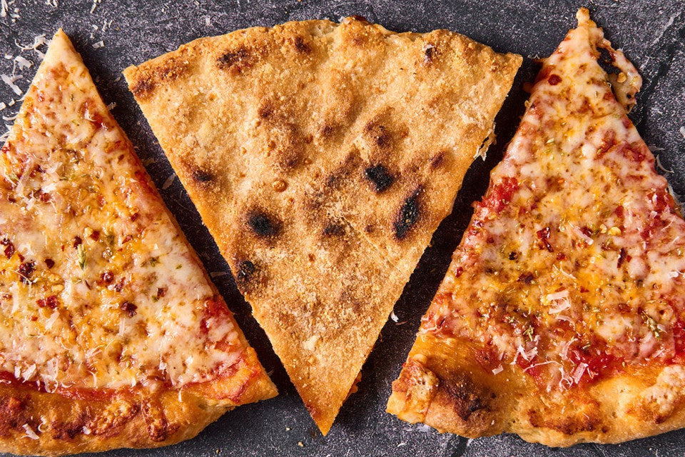 Three slices of Gluten Free NY Style Pizza with the middle one face down to show the well baked GF crust.