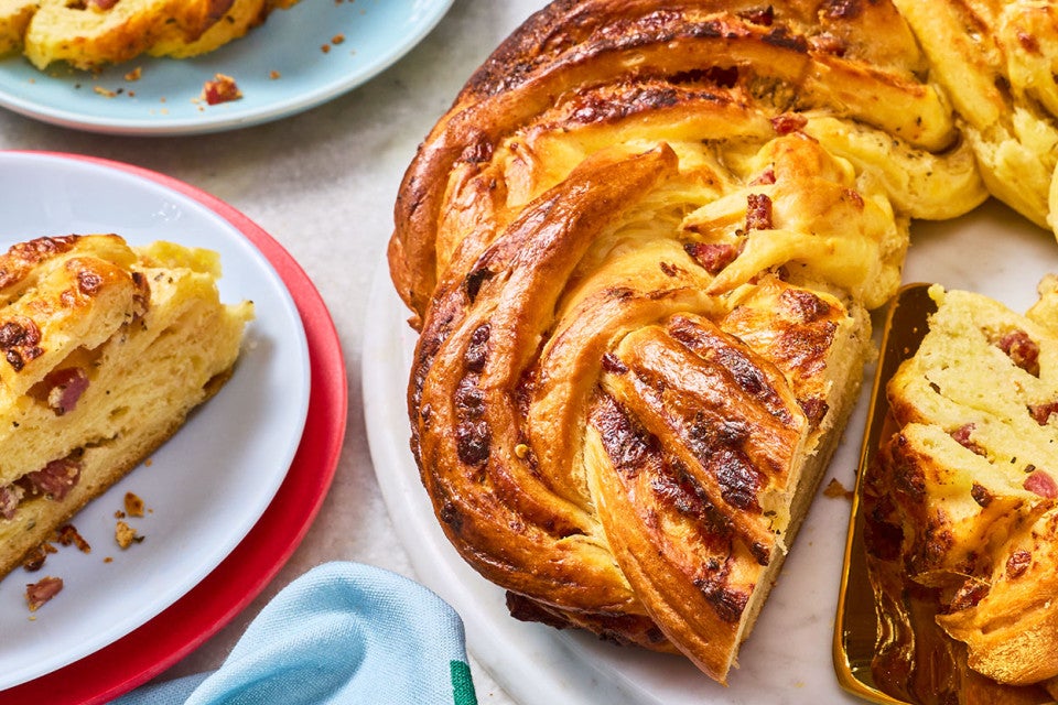 Close up of an Italian Herb & Cheese Wreath sliced and arranged on plates.