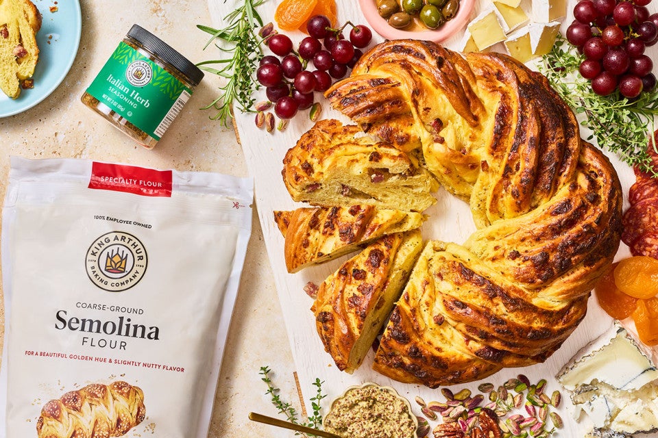 An Italian Herb & Cheese Wreath seen from above with a bag of semolina flour and italian herb blend from King Athur Baking