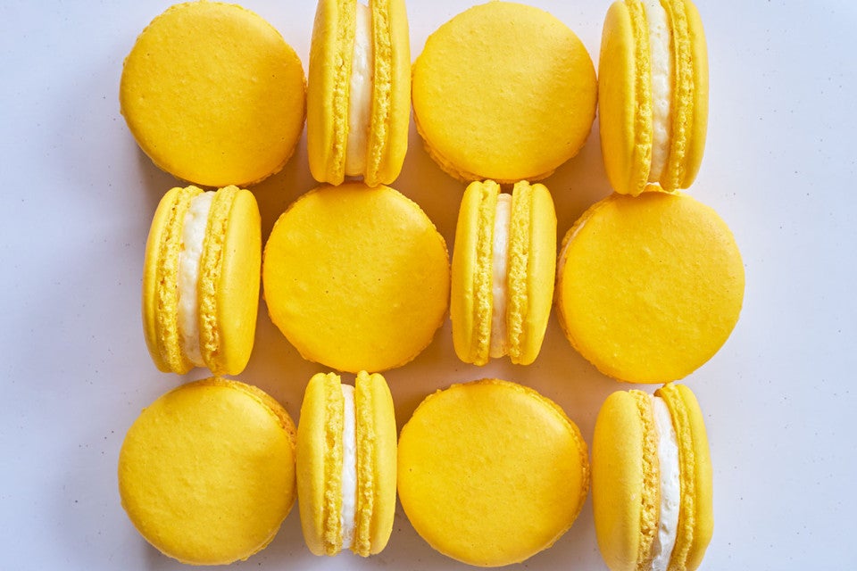 Lemon macarons arranged on a counter and seen from above.