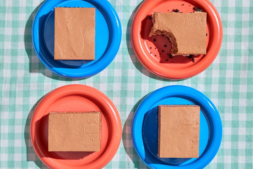 Four slices of No-Bake Chocolate Cheesecake Bars on a table on blue and red plates