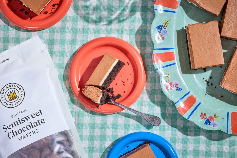 No-Bake Chocolate Cheesecake Bars on a table with a bag of Semisweet Chocolate