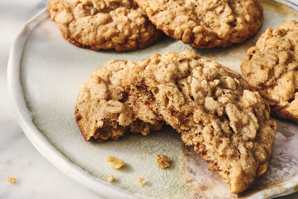 Oatmeal Cookies on a plate, one has a bite take out of it.