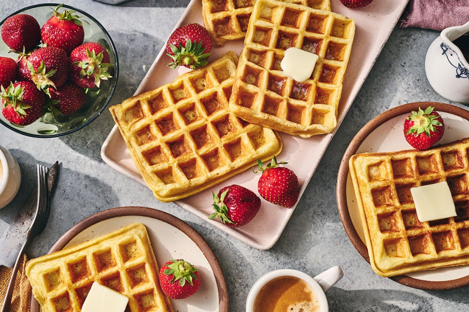 Waffles arranged on plates with fresh fruit